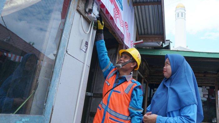 Rona bahagia terpancar dari wajah Jumaidah (kanan) penerima manfaat program Light Up The Dream di Kecamatan Gandus, Palembang oleh petugas PLN.
