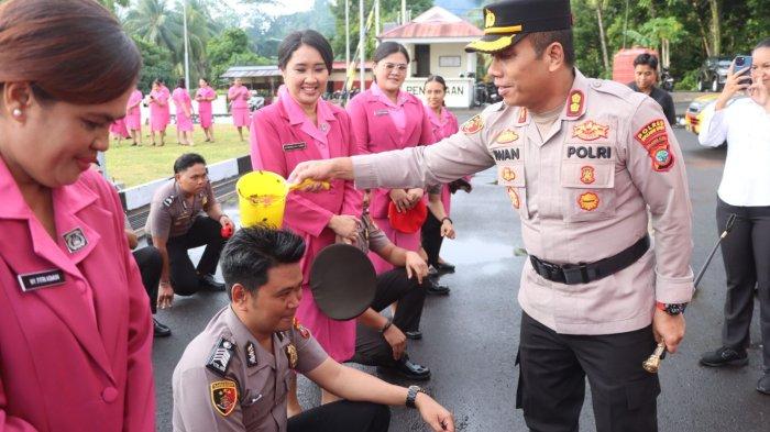 POLRES SITARO - Kapolres Sitaro AKBP Iwan Permadi menyiram polisi yang naik pangkat, Senin (30/6/2025). Sebanyak 23 personel di Polres Sitaro, Provinsi Sulawesi Utara, mendapatkan kenaikan pangkat satu tingkat.