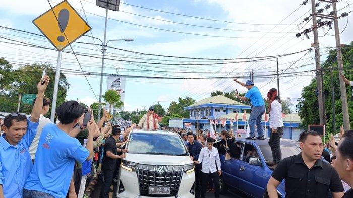 Prabowo Subianto menyapa pendukungnya dari atas mobil saat tiba di Manado, Sulawesi Utara, Senin (5/2/2024).