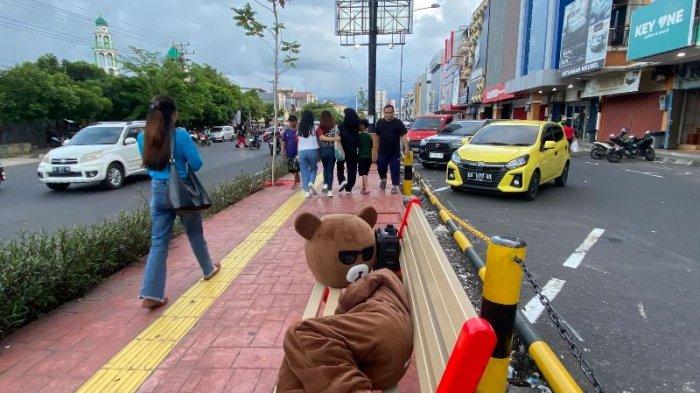 Seorang badut cilik di Kota Manado Sulawesi Utara di kursi pedestrian di Jalan Boulevard, Selasa (9/1/2024).
