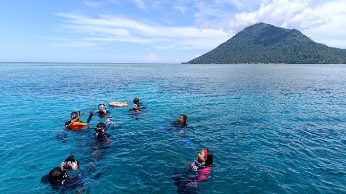 BUNAKEN - Wisatawan tamu The Divers Retreat snorkeling menikmati keindahan Taman Laut Bunaken di Spot Fukui, Jumat (23/5/2025).