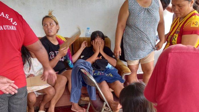 Karen Sigarlaki ketika ditenangkan keluarganya karena rumahnya di Jaga 5 Desa Kolongan, Kalawat, Minahasa Utara (Minut), Sulawesi Utara, terbakar, Minggu (10/9/2023).