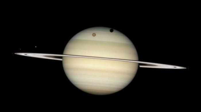 Ilustrasi Titan bulan Saturnus saat mengorbit di planet bercincin. Bulan terbesar di tata surya, setelah Ganymede bulan Jupiter.