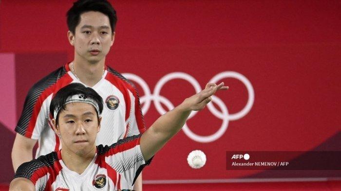 Pebulutangkis Indonesia Marcus Fernaldi Gideon (kiri) bersama pasangannya Kevin Sanjaya Sukamuljo dalam pertandingan penyisihan grup bulu tangkis ganda putra melawan Chirag Shetty dari India dan Satwiksairaj Rankireddy dari India selama Olimpiade Tokyo 2020 di Musashino Forest Sports Plaza di Tokyo pada 26 Juli, 2021. Alexander NEMENOV / AFP