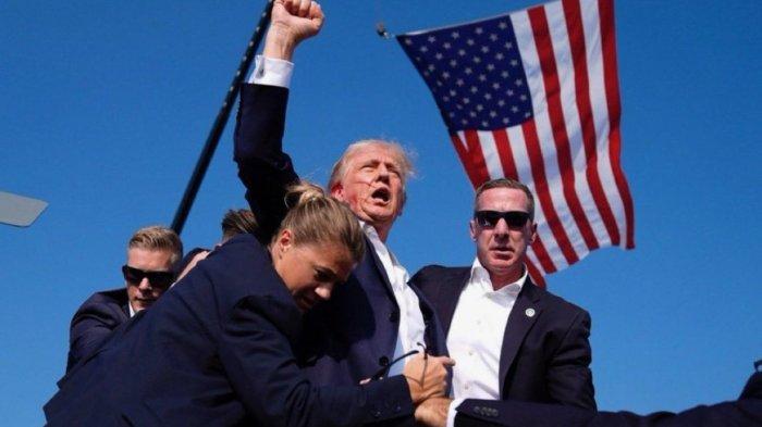 Usai tertembak orang yang tak dikenal Donald Trump justru masih bisa berdiri dan kepalkan tangan.