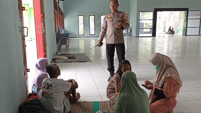 Personel Polsek Kota Bojonegoro saat meninjau keluarga Basri yang mengungsi di Gedung Serba Guna, Senin (11/3/2024) siang.
