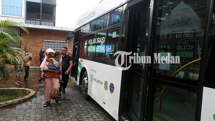 Sejumlah penumpang turun dari bus listrik saat tiba di Halte J City, Kota Medan, Rabu (1/5/2024). Pemko Medan melalui Dishub Medan mengoperasikan empat unit bus listrik gratis dengan 38 titik halte untuk mewujudkan transportasi umum yang ramah lingkungan di Kota Medan.