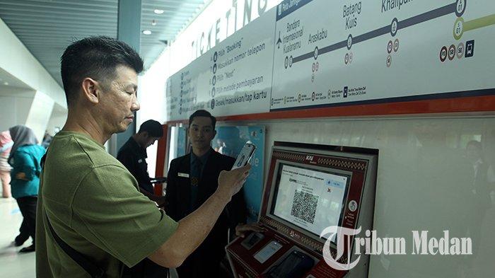 Petugas membantu pemesanan tiket calon penumpang kereta api melalui mesin di Stasiun Railink Kereta Api, Medan, Senin (1/7/2024). Tiket kereta api bandara kini turun harga menjadi Rp 40.000 per orang dari harga normal Rp 65.000 per orang.