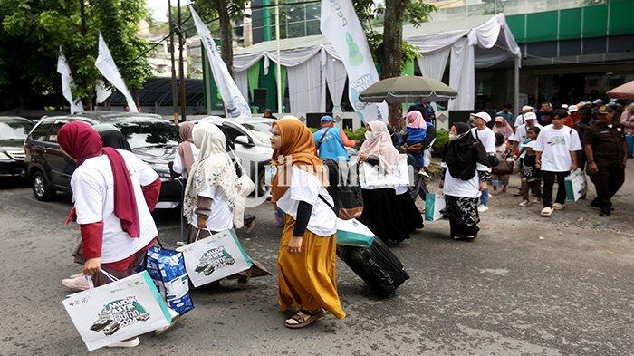 Calon pemudik berjalan menuju bus saat Mudik Asyik bersama BUMN 2024 di Kantor Pegadaian Wilayah I Medan Jalan Pegadaian Nomor 112, Aur, Kecamatan Medan Maimun, Kota Medan, Kamis (4/4/2024). PT Pegadaian Kantor Wilayah Sumut-Aceh menyediakan 6 bus gratis untuk 220 calon pemudik ke enam tujuan kampung halamannya di sejumlah daerah Kota/Provinsi di Sumatra pada lebaran Idul Fitri 1445 Hijriah.