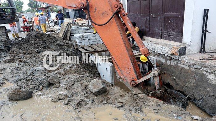 Pekerja mengoperasikan ekskavator untuk mengeruk lumpur saat perbaikan drainase di Jalan Gurilla, Kota Medan, Selasa (5/9). Wali Kota Bobby Nasution mengakui pengerjaan pembangunan drainase di Kota Medan sudah terlambat dua bulan dari waktu yang ditetapkan.