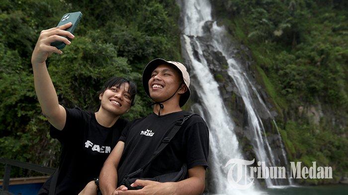 Peserta Famstrip Toba Dinas Kebudayaan dan Pariwisata (Disbudpar) Sumut berswafoto mengabadikan keindahan air terjun Situmurun di Danau Toba, Samosir, Rabu (8/6/2022). Disbudpar Sumut menggelar Famstrip selama empat hari, untuk mempromosikan pesona wisata di kawasan kaldera Danau Toba.