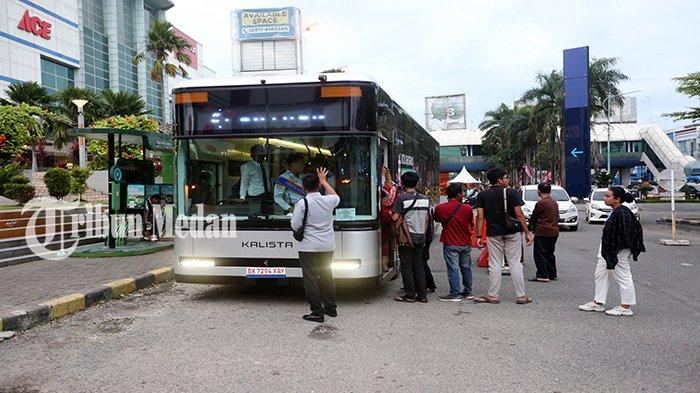 Warga mengantre masuk ke dalam bus listrik di Halte Plaza Medan Fair Jalan Gatot Subroto, Kota Medan, Selasa (9/1). Wali Kota Medan Bobby Nasution meresmikan empat mobil listrik, sumbangan dari perusahaan swasta PT Kalista Soter Hastia.