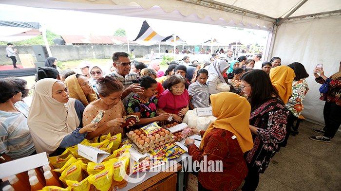 Warga mengantre membeli sembako saat kegiatan Pasar Murah di Lapangan Baronet Jalan Starban, Kecamatan Medan Polonia, Kota Medan