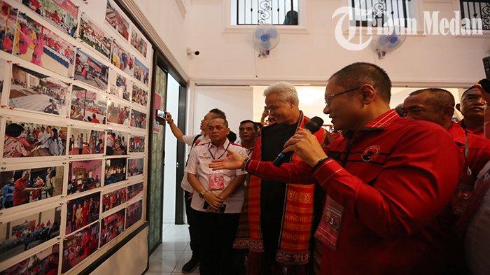 Ketua Panitia Safari Politik Paul Baja M Siahaan (kanan) menjelaskan kepada Calon Presiden yang diusung dari PDIP Ganjar Pranowo (tengah) saat memperlihatkan foto yang terpajang di dinding Rumah Pemenangan Ganjar di Jalan Sei Serayu Nomor 25, Kota Medan, Minggu (11/6) siang. Ketua DPD PDIP Sumut, Rapidin Simbolon mengatakan, konsolidasi ini sebagai bentuk kesolidan dalam kemenangan Ganjar Pranowo untuk menjadi Presiden di 2024 mendatang.
