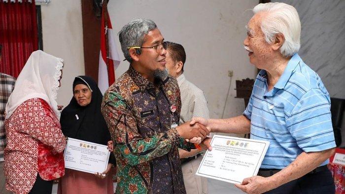 Sekda Provinsi Jateng, Sumarno, menyerahkan uang kerohiman warga terdampak Jalan Tol Semarang-Demak, di Kantor Kecamatan Genuk, Kota Semarang, Kamis (14/12/2023). (Istimewa)