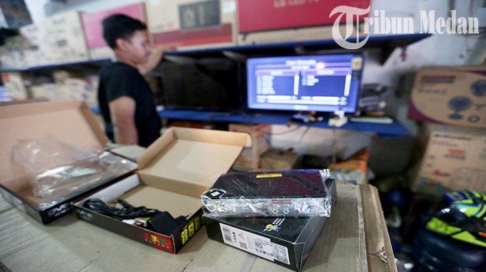 Seorang pramuniaga mencoba Set Top Box (STB) baru di Abadi Electronic Jalan Brigjend Katamso, Kota Medan, Senin (31/7). Kepala Dinas Komunikasi dan Informasi (Kominfo) Kota Medan, Arrahman Pane menanggapi persoalan siaran TV analog yang mulai dimatikan per hari ini.