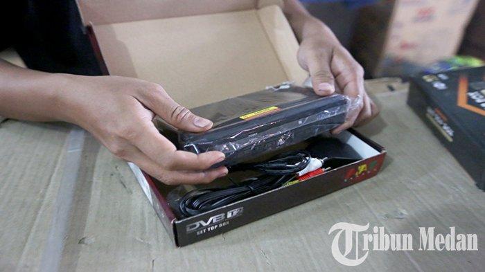 Seorang pramuniaga memperlihatkan Set Top Box (STB) baru di Abadi Electronic Jalan Brigjend Katamso, Kota Medan, Senin (31/7). Kepala Dinas Komunikasi dan Informasi (Kominfo) Kota Medan, Arrahman Pane menanggapi persoalan siaran TV analog yang mulai dimatikan per hari ini.