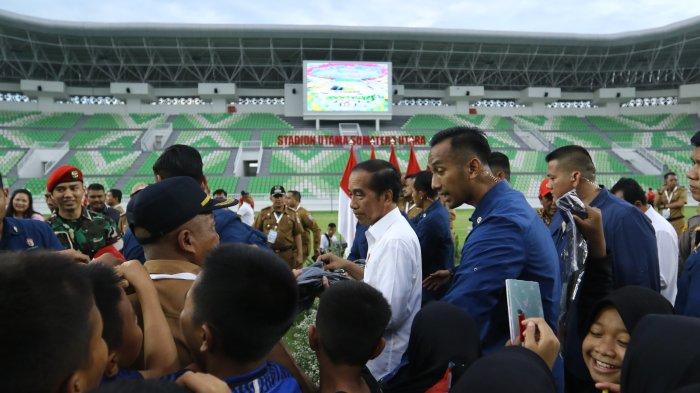 Presiden Jokowi membagikan cenderamata seusai meresmikan Stadion Utama Sumatra Utara, Deliserdang, Selasa (15/10/2024). Jokowi melakukan kunjungan kerja ke Sumatra Utara guna meresmikan bangunan bendungan, Stadion dan jalan tol.
