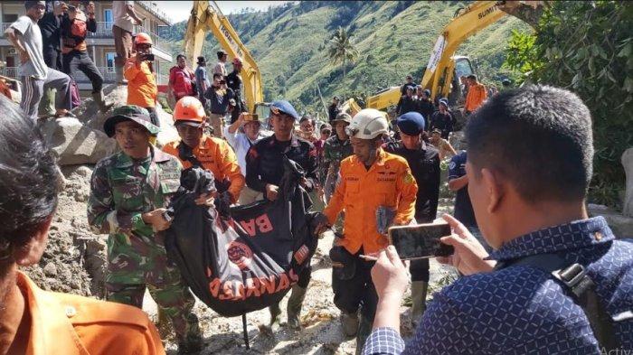 Beberapa orang petugas gabungan tampak sedang membawa jenazah korban longsor dan banjir bandang di Humbahas, yang berhasil ditemukan tadi pagi, Senin (4/12/2023).