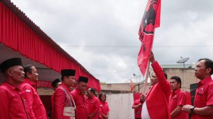 Nikodemus Munte mengibarkan bendera pataka PDI Perjuangan pertanda resmi sebagai Ketua PAC PDI Perjuangan Kecamatan Dolok Sanggul Humbang Hasundutan usai diberi Ketua DPC PDI Perjuangan Humbang Hasundutan Oloan Paniaran Nababan disaksikan Ketua DPD PDI Perjuangan Sumut Rapidin Simbolon di Kantor DPC PDI Perjuangan Humbahas, Selasa (7/11/2023).