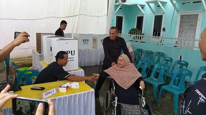 Calon Gubernur Sumatera Utara nomor urut 2, Edy Rahmayadi dorong ibu di kursi roda ke TPS 44 Bakti Karya, Medan Johor, Rabu (27/11 /2024)