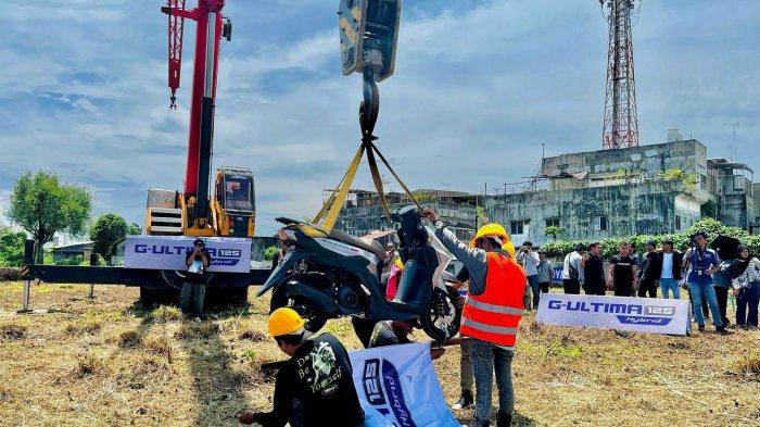 DITURUNKAN DARI CRANE - Dengan rangka underbone setebal 2,3 mm, G-Ultima 125 Hybrid diuji langsung di hadapan publik di Simpang Glugur, Medan Barat, Rabu (30/4). Motor matic ini berhasil diangkat setinggi 30 meter dan mencuri perhatian publik