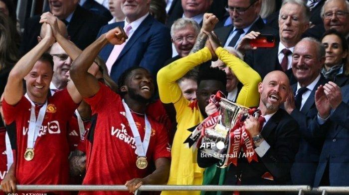 Manajer Manchester United asal Belanda Erik ten Hag mengangkat trofi untuk merayakan kemenangan mereka di penghujung pertandingan sepak bola final Piala FA Inggris antara Manchester City dan Manchester United di stadion Wembley, London, pada 25 Mei 2024. Manchester United menang 2 - 1 melawan Manchester City. Ben Stansall / AFP