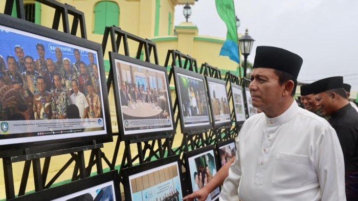 Gubernur Kepri H Ansar Ahmad saat melihat pajangan foto dalam satu kegiatan yang ia lakukan dalam membangun dan membina jiwa umat.