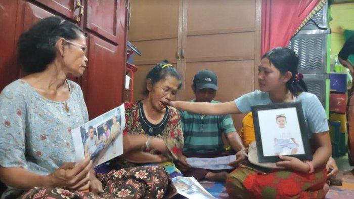 Ibu Sempurna Pasaribu (tengah), menangis sambil memandangi foto korban bersama keluarganya semasa hidup, di rumah duka keluarga korban, di Jalan Irian, Kabanjahe, Sabtu (29/6/2024). (TRIBUN MEDAN/MUHAMMAD NASRUL)