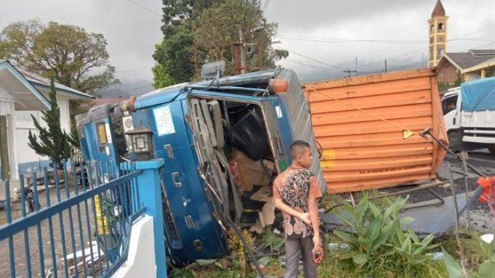 LAKALANTAS TRUK - Kondisi truk kontainer pengangkut biji kopi terguling seusai menabrak truk tangki air hingga merobohkan pagar depan kantor Desa Bandar Baru, Rabu (12/2/2025). Dua truk sama-sama rusak dan satu sopir luka-luka.