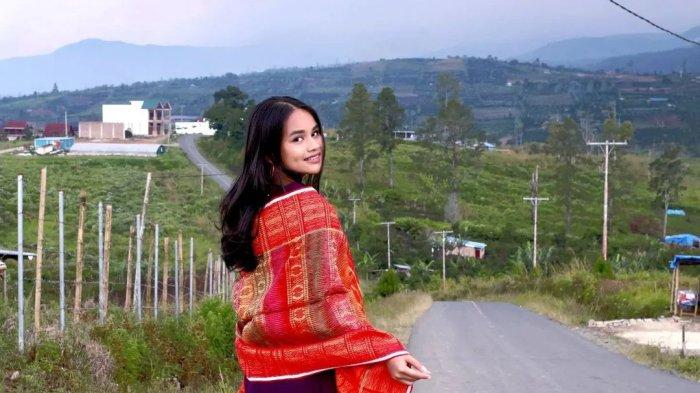 Pengunjung bergaya dengan latar perbukitan hijau di Puncak 2000 Siosar, Desa Nagara, Kecamatan Merek, Kabupaten Karo, Sumatera Utara.