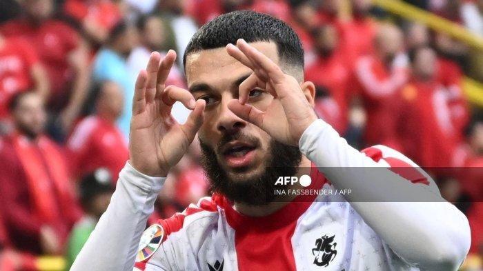 Penyerang Georgia #22 Georges Mikautadze merayakan mencetak gol pertama timnya selama pertandingan sepak bola Grup F UEFA Euro 2024 antara Turki dan Georgia di BVB Stadion di Dortmund pada 18 Juni 2024. Sebanyak empat tim lolos ke 16 besar melalui jalur peringkat tiga terbik, Georgia cetak sejarah. (INA FASSBENDER / AFP)