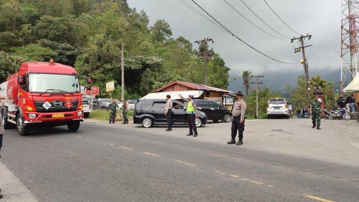 Petugas melakukan pengamanan di pintu masuk Sidebuk-Debuk, Minggu (19/3/2023). Jalur menuju pemandian air panas tersebut sempat diblokir akibat adanya perselisihan antara pengutip dan pengawas retribusi. Tapi kini pungli muncul lagi