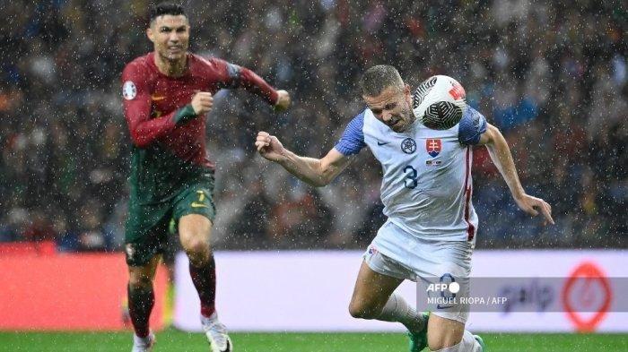 Penyerang Portugal #07 Cristiano Ronaldo berebut bola dengan bek Slovakia #03 Denis Vavro selama pertandingan sepak bola kualifikasi grup A putaran pertama EURO 2024 antara Portugal dan Slovakia di stadion Dragao di Porto pada 13 Oktober 2023.