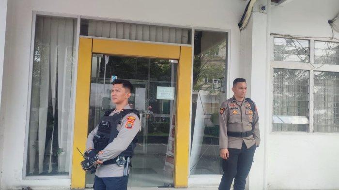 Sejumlah petugas kepolisian sedang berjaga di pintu masuk Kantor PUPR Sumut jalan Sakti Lubis, Medan, Selasa (1/7/2025). Ada lebih dari enam orang KPK yang menggeledah kantor PUPR Sumut.