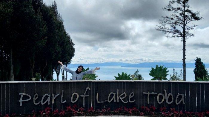 Seorang pengunjung sedang berfoto di pearl of lake toba Taman Simalem Resort