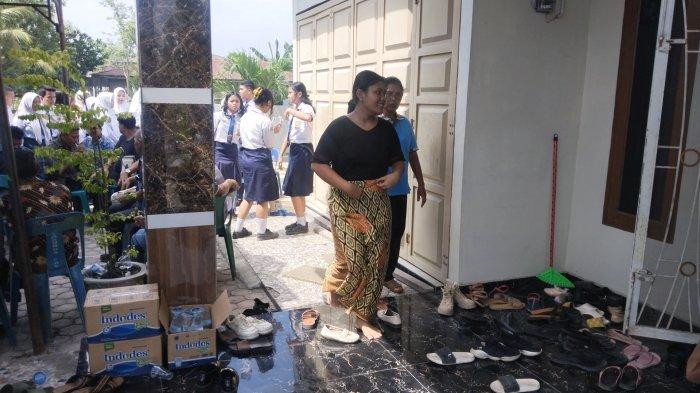 Setia Manullang ketika berada di teras rumah dan hendak masuk ke dalam rumah untuk bisa dekat dengan peti jenazah ayah dan lima saudara kandungnya Senin, (22/7/2024).