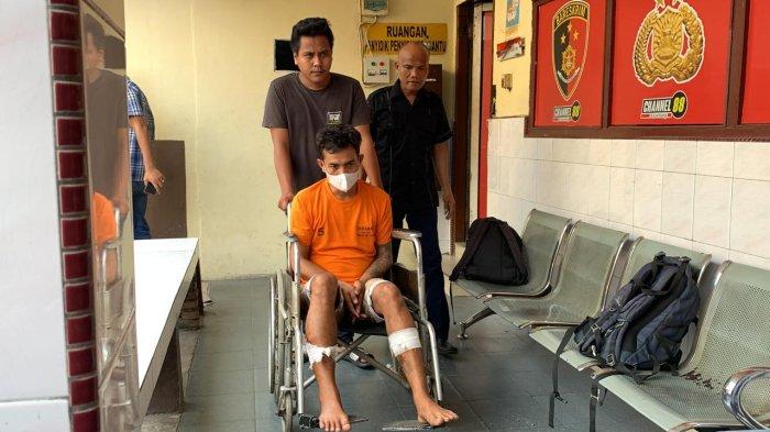 Tampang Reza Adrian Siregar alias Reza, pelaku pembunuhan pedagang mie Aceh duduk di kursi roda saat dihadirkan oleh polisi saat konferensi pers di Polsek Medan Tembung, Kamis (25/7/2024).