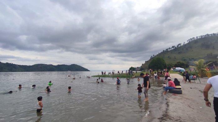 Wisatawan menikmati sejuknya air Danau Toba saat berlibur di objek wisata Pantai Sinalsal, Desa Tongging, Kecamatan Merek, Kabupaten Karo, belum lama ini.