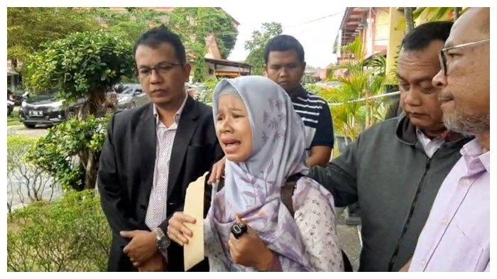 Yuliani, istri tersangka H dalam kasus polisi bunuh warga tak kuasa menahan tangis ketika memberikan keterangan bersama kuasa hukumnya, Parlin B Hutabarat, Senin (16/12/2024). (TRIBUNKALTENG.COM/AHMAD SUPRIANDI)