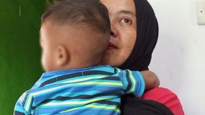 Siti Maulia (37), ibu dari bayi yang tertukar sedang menggendong bayi tersebut di rumahnya Kampung Mekar Jaya, Desa Cibeuteng, Kecamatan Ciseeng, Kabupaten Bogor, Jawa Barat, Jumat (11/8/2023). Hingga saat ini, Siti Maulia berharap agar anaknya bisa ditemukan. Sekarang Siti Maulia telah membesarkan bayi yang ditukarkan tersebut. (KOMPAS.COM/AFDHALUL IKHSAN)