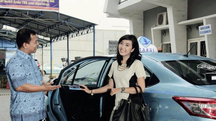Supir Blue Bird saat membukakan pintu untuk penumpang.