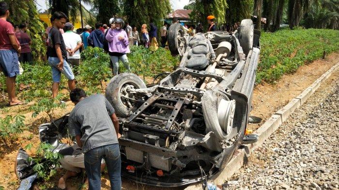 Warga melakukan evakuasi mobil Innova Reborn yang ditabrak kereta api di perlintasan tanpa palang pintu di Jalan Abdul Hamid, Kecamatan Padang Hilir, Kota Tebingtinggi, Minggu (14/1/2024).
