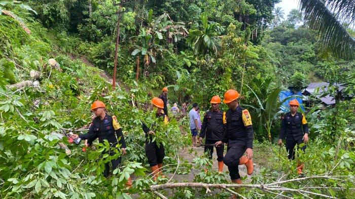 Anggota Brimob Polda Sumut membantu warga membersihkan material longsor di Desa Onowaembo, Gunung Sitoli. Dalam suasana penuh kepedulian, mereka bekerja sama dengan masyarakat untuk mengembalikan akses jalan yang tertutup longsor.