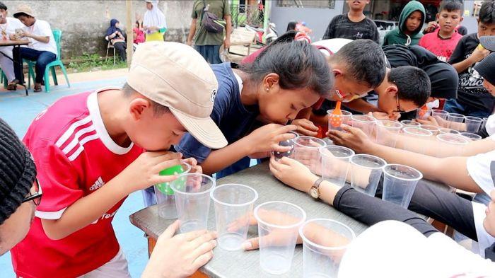 Lomba meniup bola di dalam gelas saat momen 17 Agustus