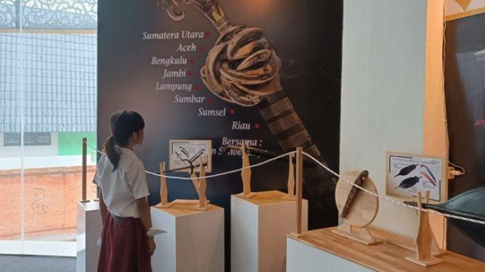 Seorang pelajar tengah serius memperhatikan senjata tradisonal yang dipamerkan di Museum Negeri Sumatera Utara.