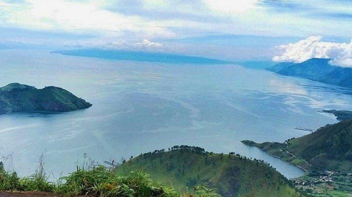 Pemandangan Danau Toba dan bukit savana dari puncak Bukit Gajah Bobok