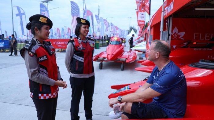 Personel Polisi pariwisata Polda Sumutsedang berinteraksi dengan peserta F1 Powerboat di Ballige, Jumat (1/3/2024).