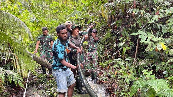 Warga Kampung Sisik, Distrik Keureh Lereh, Kabupaten Jayapura, Papua, penuh haru bahagia saat mendapatkan air bersih, Senin (25/12/2023). Air bersih yang dialirkan dari pegunungan melalui selang berukuran besar itu terlihat dikerjakan pasukan TNI dan dibantu oleh warga. (Dispenad)