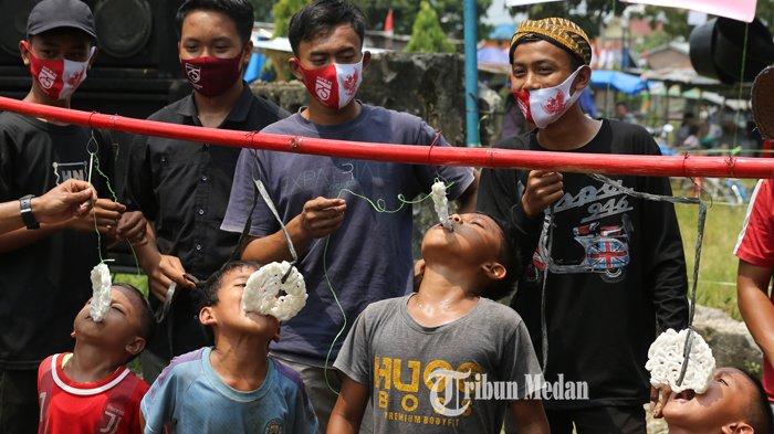 Sejumlah warga dengan menggunakan masker mengikuti perlombaan 17 Agustusan di Sei Mencirim, Kabupaten Deliserdang, Sumatera Utara, Senin (17/8/2020). Meski masih ditengah pandemi COVID-19 tidak menyurutkan warga untuk menyambut perayaan HUT ke-75 Republik Indonesia dengan menerapkan protokol kesehatan.TRIBUN MEDAN/RISKI CAHYADI